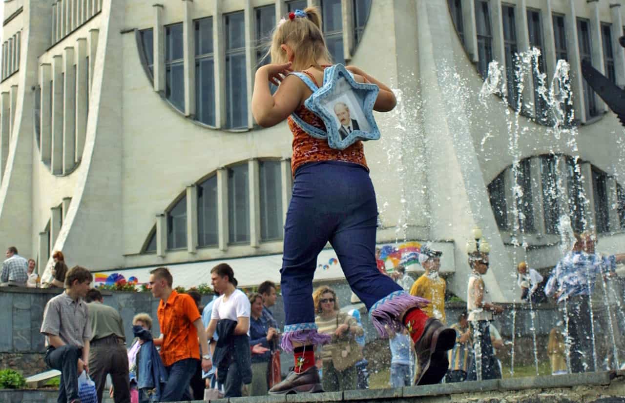 BELARUS / Grodno / June 6, 2004 / Small girl with Aleksand LukashenkoÊportrait in the bag pass away theÊfountainÊnext to the local Drama Theater. © Andrei Liankevich / Anzenberger