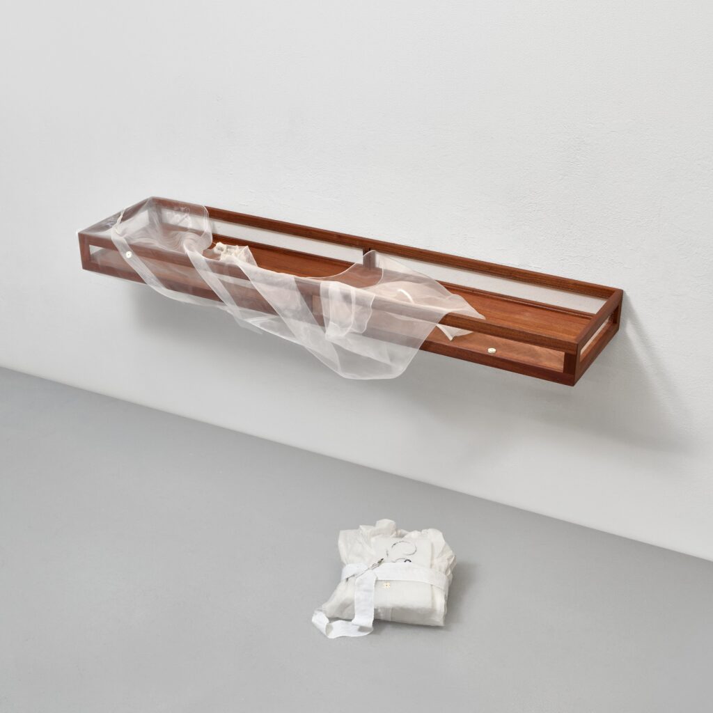 Linda Lach, Let’s not let them get the better of us, 2026, mahogany, glass, organza, cotton 130 × 11 cm